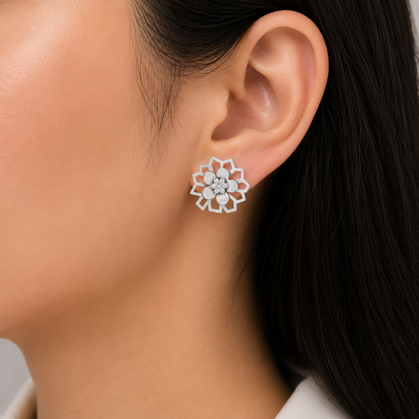 A close-up of a woman's ear wearing a white floral stud diamond earring with a clear crystal center.