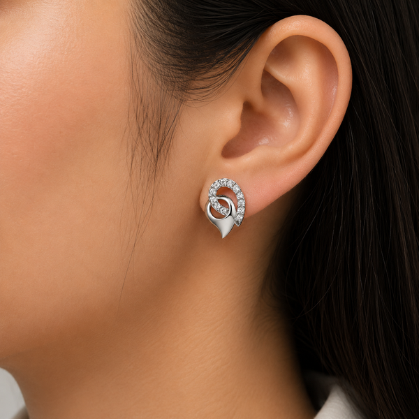 A close-up of a model's ear wearing a silver spiral stud diamond  earring adorned with small clear diamond.