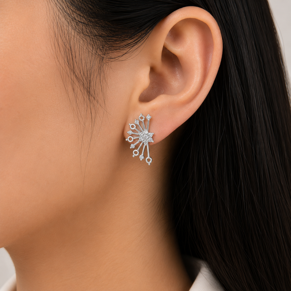 A close-up of a model's ear wearing a silver-toned, multi-prong starburst stud diamond earring with clear diamonds .