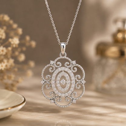 A silver filigree pendant necklace with clear diamonds, hanging from a delicate silver chain against a warm, softly blurred background with decorative dried flowers.