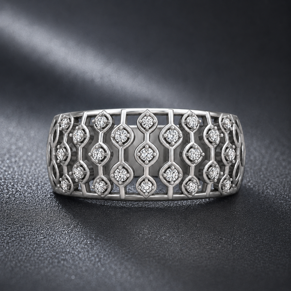 A silver-toned wide band ring featuring an intricate openwork geometric trellis pattern set with small clear round-cut stones, photographed on a dark textured surface.