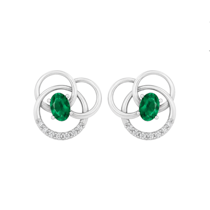 A pair of silver-toned stud diamond  earrings featuring an oval-cut green emerald center stone and a crescent-shaped border set with small clear diamond, shown on a plain white background.